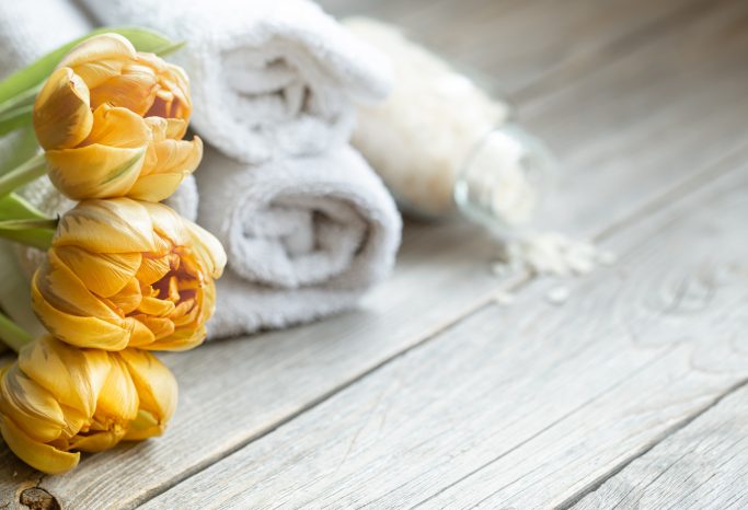 Serviette blanche sur le sol avec des fleurs jaunes